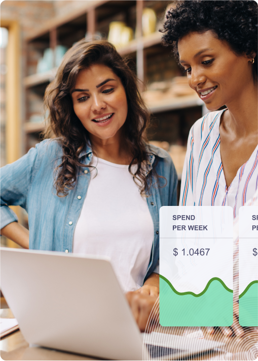 Two women standing in front of a laptop discussing online banking 