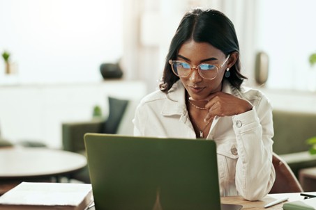 Woman at a laptop comparing how money market accounts work and their interest rates